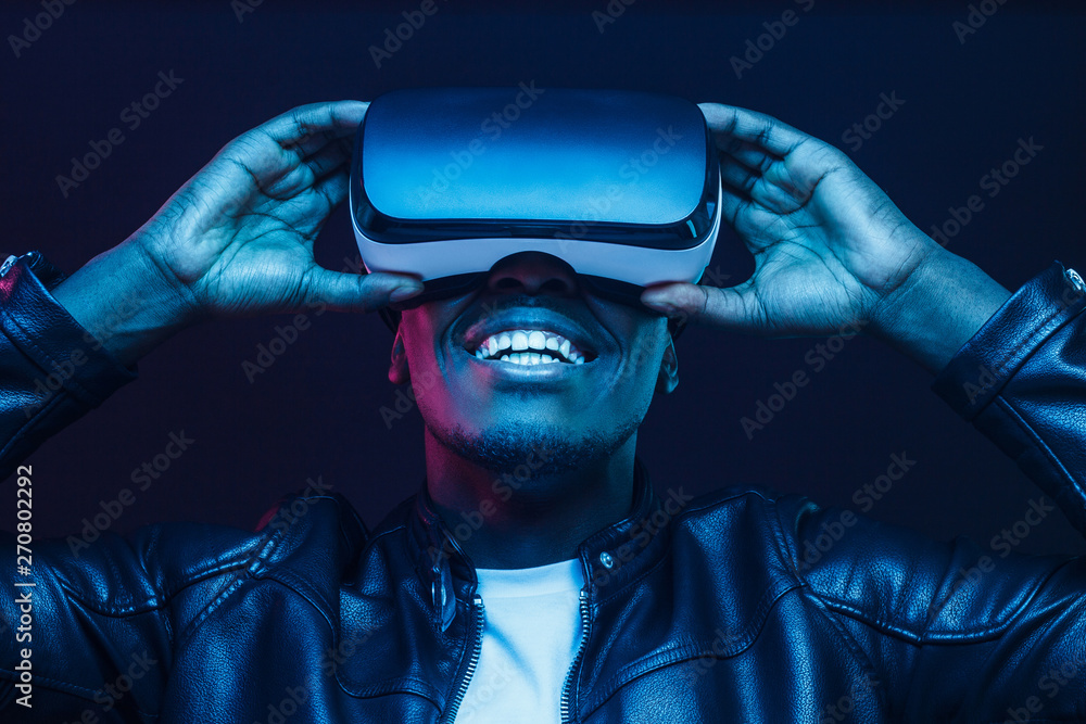 African man wearing virtual reality headset having great fun - obrazy, fototapety, plakaty 