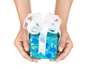 Sticker - Hand holding blue gift box with ribbon isolated on white background