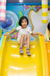 Leinwandbild Motiv Asian Chinese little girl playing on the slide