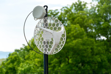 Internet outdoor wireless antenna metal rod on the roof and green tree and sky in the background. Modern technology and internet concept. Close up, selective focus