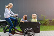 © pikselstock - Mother and children having a ride with cargo bike