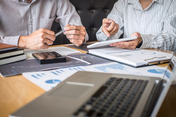 Stock exchange market concept, Team of investment trading or stock brokers having a consultation and analyzing with display screen and pointing on the data presented and deal on a stock exchange