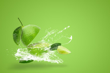 Water Splashing On Fresh Green Lime Isolated On Green Background