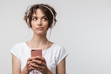 Image Of Joyful Woman In Basic T-shirt Holding Smartphone While Listening To Music With Headphones
