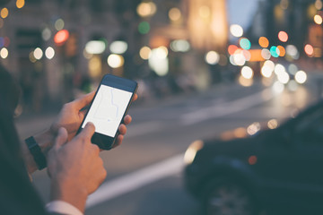 Close up of man's hands with smartphone. Tourist using GPS map navigation on application screen for direction to destination address in the city. Travel and technology concept