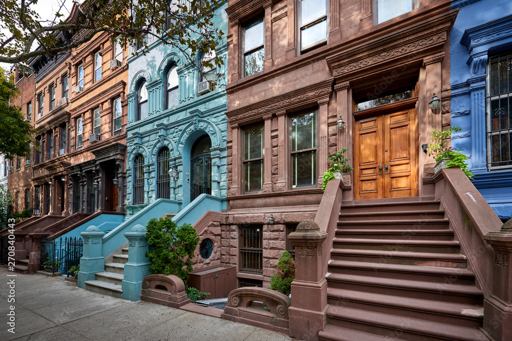 a view of a row of historic brownstones in an iconic neighborhood of Manhattan, New York City - obrazy, fototapety, plakaty 