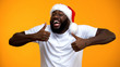 © motortion - Excited African-American Santa man showing thumbs up, Happy Christmas holidays