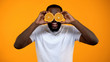 © motortion - Joyful Afro-American man closing eyes with half of oranges, vitamins for health
