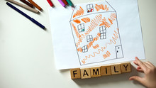 Family Word Made Of Cubes Lying Near Kids House Drawing, Orphan And Charity