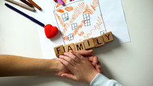 Child Holding Hand Of Adult Person, Family Word Made From Cubes On House Picture