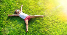 Smiling Little Girl Lying On Grass Meadow