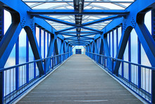 The Prospect Of A Long Corridor Of A Pedestrian Bridge Made Of Bright Blue Iron Construction
