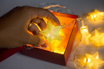 Hand holding christmas lamp star on white background