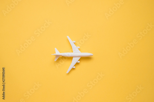 Fotografering  Flat lay design of travel concept with plane on yellow background with copy space