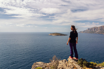 Wall Mural - Young woman enjoying beautiful view. Kalymnos Island, Greece.