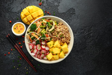 Asian style Vegan salad bowl with edamame, vegetable stir-fry mix, wholegrain rice, quinoa, mango chunks drizzled with mango, chilli dressing