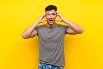 Handsome man over isolated yellow wall with surprise expression