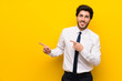 © luismolinero - Businessman on isolated yellow background pointing finger to the side