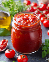 Traditional Tomato Sauce In A Glass Jar With Fresh Herbs, Tomatoes And Olive Oil. Close Up.