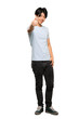 © luismolinero - A full-length shot of a Asian man with blue shirt with thumbs up because something good has happened over isolated white background