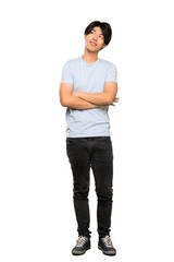 Wall Mural - A full-length shot of a Asian man with blue shirt looking up while smiling over isolated white background