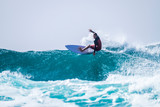 teenager surfing at the wave in tenerife playa de las americas - red wetsuits and beautiful and perfect wave