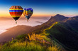 © tawatchai1990 - Landscape of morning fog and mountains with hot air balloons at sunrise.