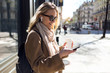 © nenetus - Pretty young woman listening to music with wireless earphones and the smartphone in the street.