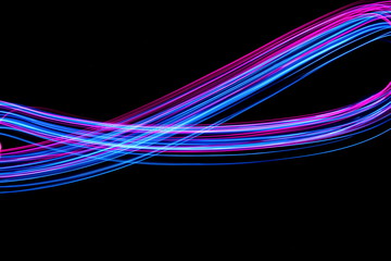 Wall Mural - Long exposure, light painting photography.  Vibrant electric blue and neon pink streaks of colour against a black background