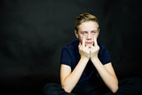 Young handsome man wearing t-shirt over black background Showing middle finger, impolite and rude fuck off expression.