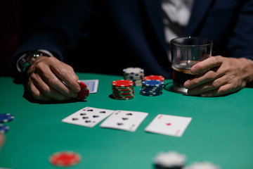 professional poker game. Green poker table with two games. poker player makes a bet by throwing chips on the table