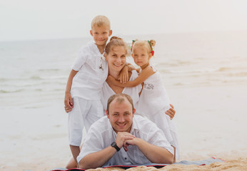 Wall Mural - Happy young family on the sunset at the beach.