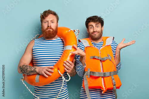Cuadros en Lienzo Serious male swim instructor with lifeline, doubtful trainee wears orange vest,