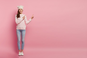 Wall Mural - Welcome there. Image of beautiful cheerful woman shows awesome advertisement, dressed in stylish clothes, says here we go, recommends perfect place, gives advice what product better to choose