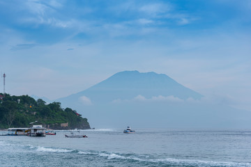 Wall Mural - beautifull view on Bali from beach, early morning with fogs in front of Agung mount vulcano, blue sky background