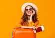 © JenkoAtaman - concept of travel. happy woman girl with suitcase and  passport on  yellow background