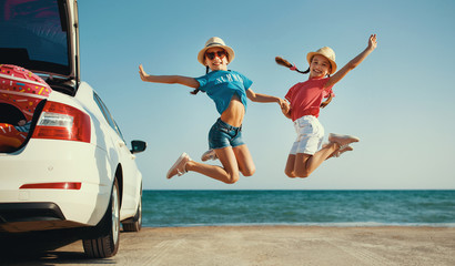 happy children girls twin sisters on car ride to summer trip.