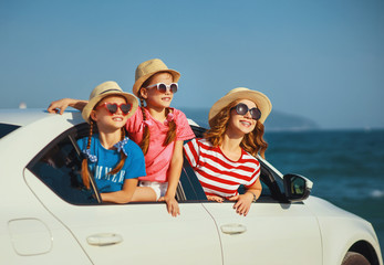 happy family mother and children girls goes to summer travel trip in car.