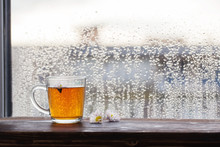 Cup Of Tea  On  Background Of  Window With Raindrops At Sunset