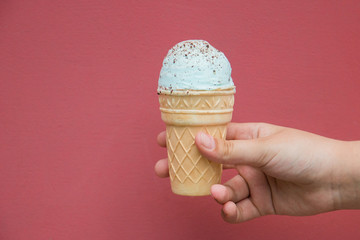 ordinary waffle Cup mint ice cream in hand on red isolated background