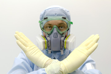 Poster - An engineer of laboratory wearing a special uniform and protective glasses and face mask against chemical poison show gesture by hands sign STOP