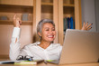 © TheVisualsYouNeed - Corporate portrait of attractive and happy successful mature Asian woman working at laptop computer desk smiling confident and charming