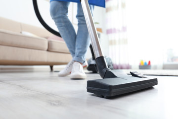 Canvas Print - Cleaning service professional vacuuming floor with hoover, closeup