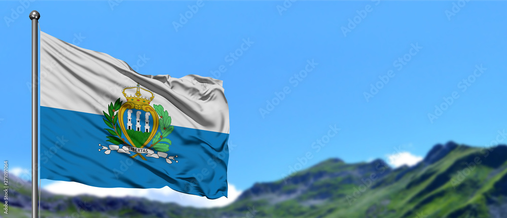 Obraz na płótnie San Marino flag waving in the blue sky with green fields at mountain peak background. Nature theme. w salonie
