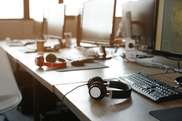 Wall Mural - Headphones and keyboard on table in internet cafe. Video game tournament