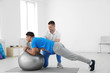 © New Africa - Professional physiotherapist working with male patient in rehabilitation center