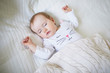 © Ekaterina Pokrovsky - Adorable baby girl sleeping in crib under knitted blanket