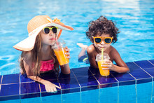 Two Kids Girl And Boy Drink Juice In The Pool And Have Fun. Children And Summer Concept