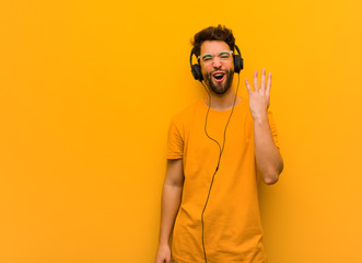 Wall Mural - Young man listening to music showing number four