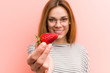 © Asier - Portrait of young woman tasting a fresh strawberry